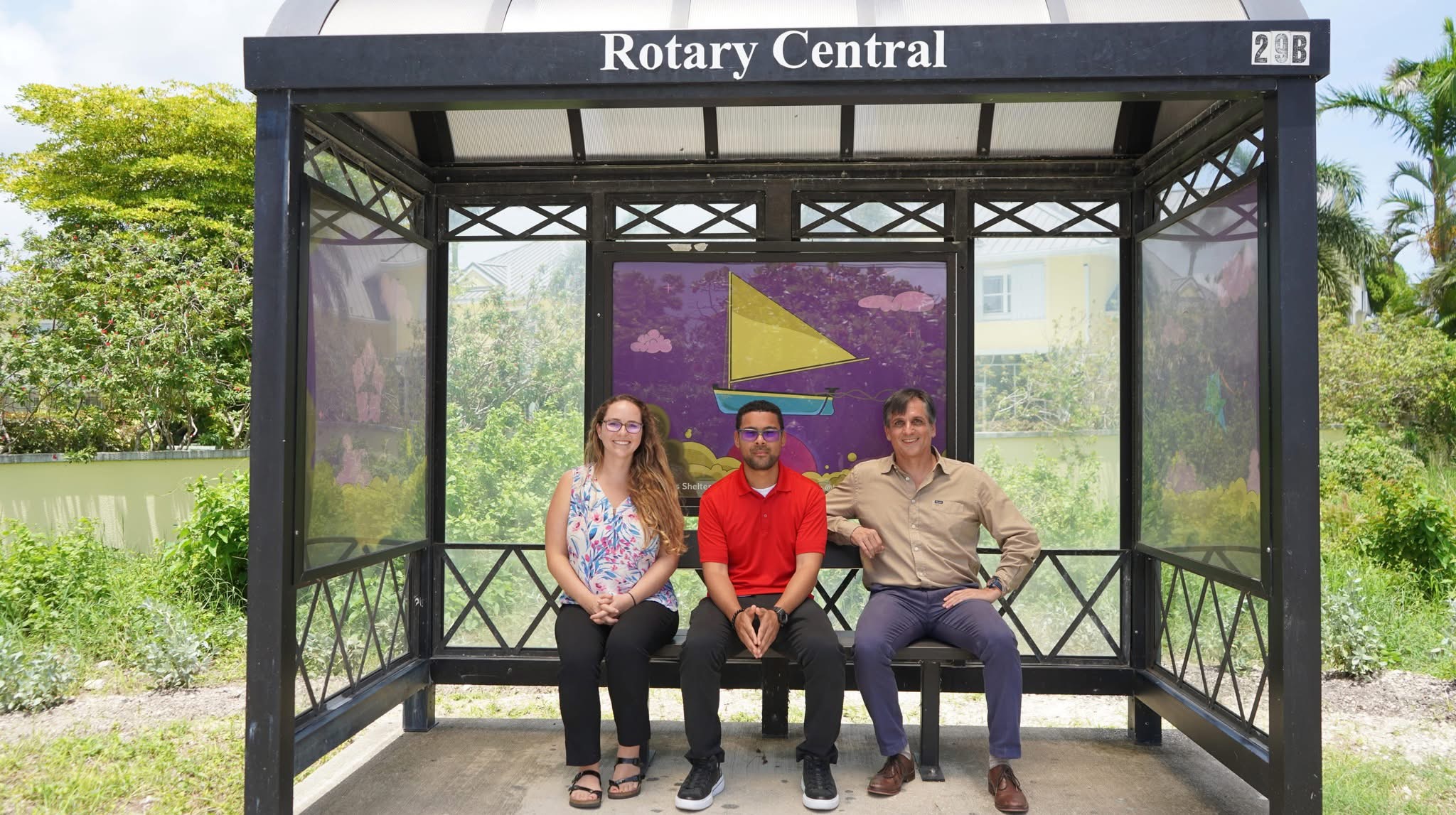 Kaitlyn Elphinstone Chief Marketing & Strategy Officer at CEC, artist Michael Mothen, and Charlie Kirkconnell Chief Executive Officer at CEC meet at Rotary Central Bus Shelter on Fairbanks Road